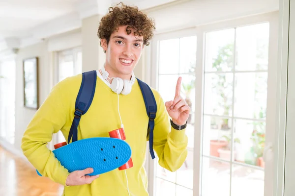 Ung Student Man Bär Hörlurar Och Ryggsäck Holding Skateboard Överraskade — Stockfoto