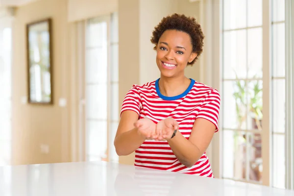 年轻美丽的非洲裔美国女人在家里微笑着用双手手掌一起接受或给予手势 保持和保护 — 图库照片