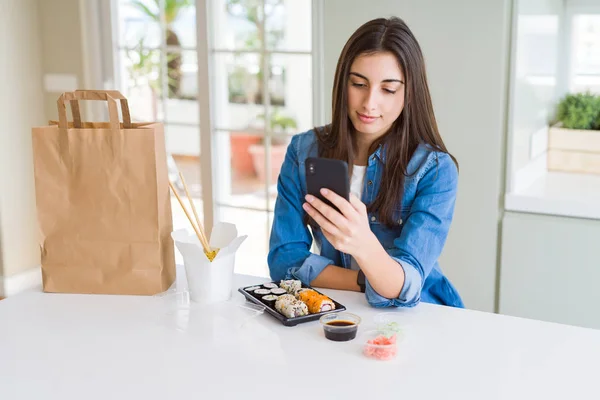 美しい若い女性考えて深刻なスマートの顔に自信を持って式のスマート フォンを使ってアプリから食品配送を注文 — ストック写真