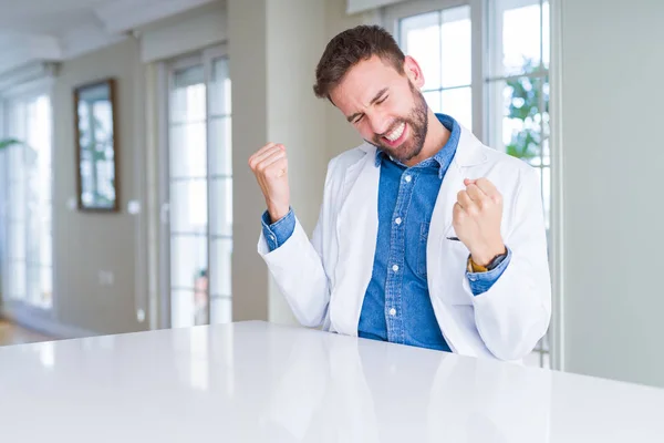 ハンサムな医者男非常に幸せと興奮の腕を上げ 勝者のジェスチャを行うクリニックで医療のコートを着て笑顔で成功のために叫んで お祝いのコンセプト — ストック写真