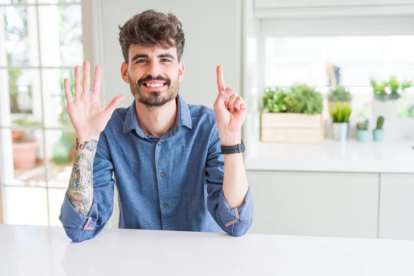 Hombre Joven Con Camisa Casual Sentado Mesa Blanca Mostrando Apuntando — Foto de Stock