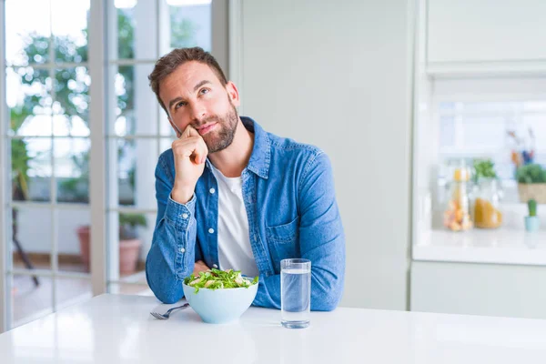 Hombre Guapo Comiendo Ensalada Sana Fresca Con Mano Barbilla Pensando —  Fotos de Stock