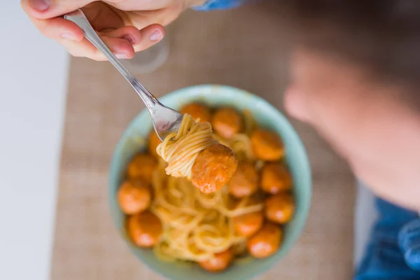 Close up of man eating a plate of pasta with meatballs and tomat — Stock Photo, Image