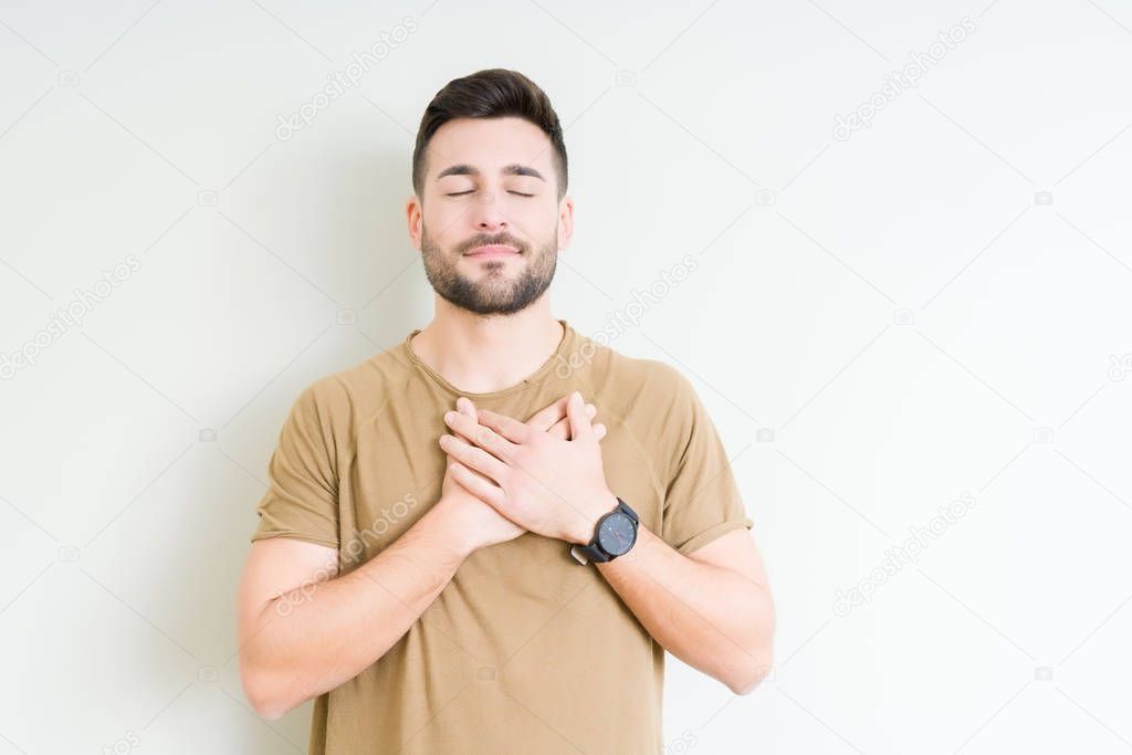 Young handsome man over isolated background smiling with hands on chest with closed eyes and grateful gesture on face. Health concept.