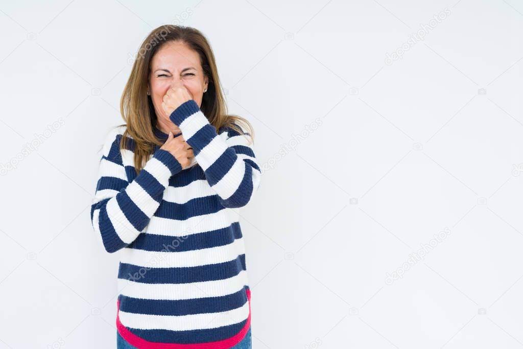 Beautiful middle age woman wearing navy sweater over isolated background smelling something stinky and disgusting, intolerable smell, holding breath with fingers on nose. Bad smells concept.