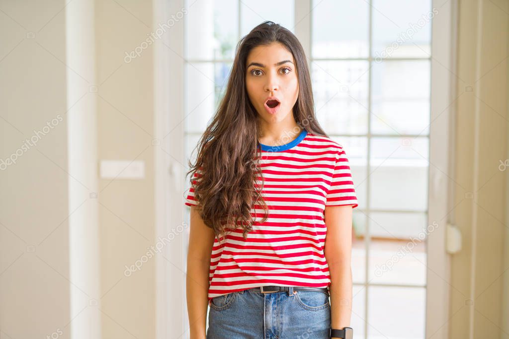 Young beautiful woman wearing casual t-shirt afraid and shocked with surprise expression, fear and excited face.