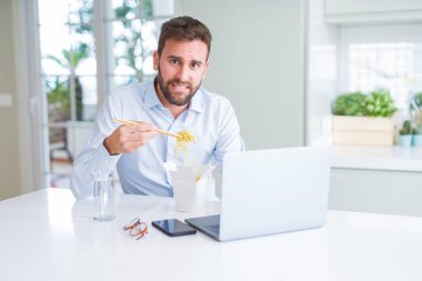 İş adam yeme Asya erişte yemek sırasında çalışma u götürün