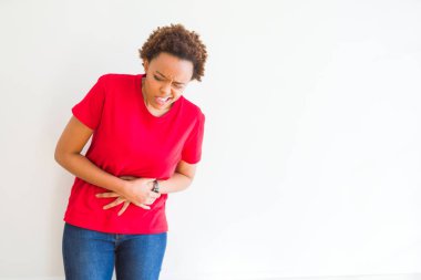 Genç güzel Afrikalı-Amerikalı kadın mide üzerinde el ile beyaz arka plan üzerinde çünkü mide bulantısı, ağrılı hastalık hasta hissediyor. Ağrısı kavramı.