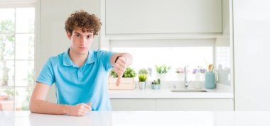 Geniş ev arıyorum, genç yakışıklı adamın mutsuz ve kızgın ret gösterilen atış ve başparmak aşağı hareketi ile negatif. Kötü ifade.