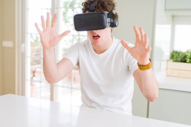 Genç adam eğleniyor evde sanal gerçeklik gözlüklü