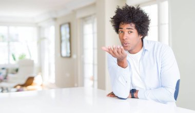 Afrika kökenli Amerikalı adam evde bir öpücük el ile güzel ve seksi olmak hava üfleme kamera bakıyor. Aşk ifade.