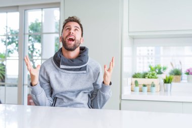 Yakışıklı adam evde deli ve deli bağırarak ve agresif ifade ve silah kaldırdı bağırıyor. Hayal kırıklığı kavramı.
