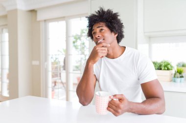 Bir fincan kahve ciddi bir yüz düşünme hakkında soru, çok karışık fikir içme afro saçlı Afrika kökenli Amerikalı adam