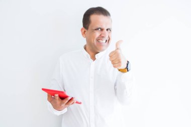 Ok işareti, başparmak ile parmak, mükemmel işareti yapıyor kocaman bir gülümseme ile beyaz duvardan mutlu dijital tablo kullanarak orta yaş erkek