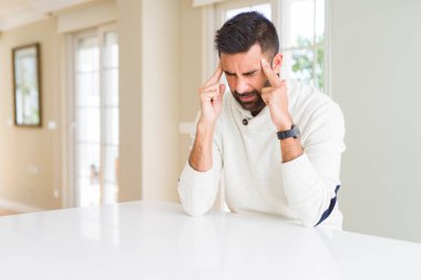 Çünkü baş ağrısı için kafasına Casual beyaz kazak evde el ile giyen İspanyol yakışıklı stres. Migren muzdarip.