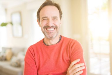 Evde kameraya bakarak gülümseyen yakışıklı orta yaş erkek