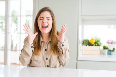 Güzel genç kadın evde deli ve çığlık kaldırdı ve kapalı gözleri heyecanlı silah ile başarı için deli kutluyor. Kazanan kavramı