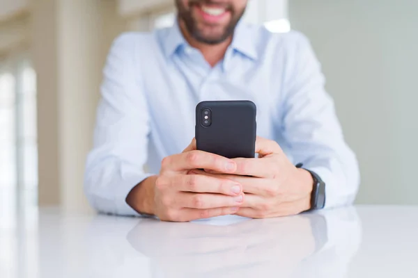Lähikuva miehen kädet älypuhelimella ja hymyillen — kuvapankkivalokuva