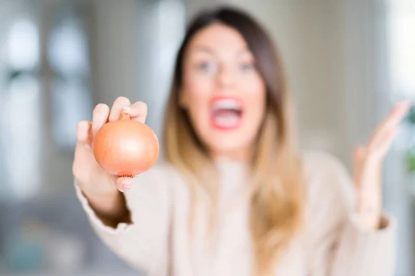 Ung Vacker Kvinna Håller Färsk Lök Hemma Mycket Glad Och — Stockfoto