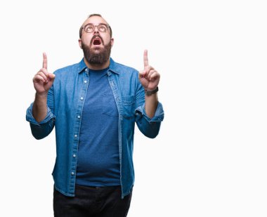 İzole arka plan üzerinde gözlüklü Genç beyaz hipster adam hayret ve yukarıya bakıp parmakları ile işaret şaşırttı ve silah kaldırdı.