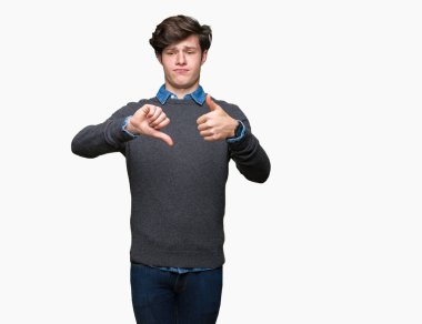 Genç yakışıklı zarif adam izole arka plan yapmaya başparmak yukarı ve aşağı, anlaşmazlık ve anlaşma ifade üzerinde. Deli çatışma