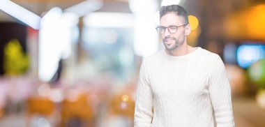 Seksi bir ifadeyle, neşeli ve mutlu yüzünü kameraya bakarak göz kırpıyor izole arka plan üzerinde gözlük takan genç yakışıklı adam.