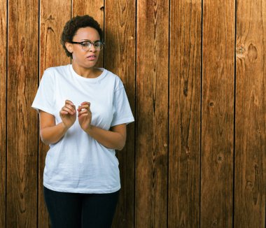 Güzel genç Afro-Amerikan kadın izole arka plan üzerinde gözlük tiksinti ifadesi, memnun ve korkulu tiksinti yüz yapıyorsun çünkü nefret tepki. Elleriyle kaldırdı. Sinir bozucu kavramı.