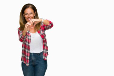 Kalp simgesi ve elleriyle şekil gösterilen aşık gülümseyen izole arka plan üzerinde rahat forması giyen orta yaş yetişkin kadın. Romantik kavramı.