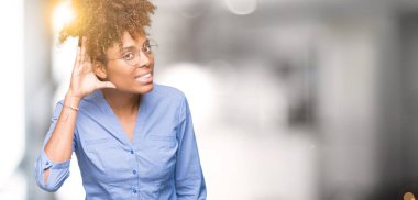 Güzel genç Afro-Amerikan iş kadını bir işitme söylenti ya da dedikodu için dinleme kulak üzerinde el ile gülümseyen izole arka plan üzerinde. Sağırlık kavramı.