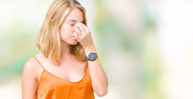 İzole arka plan yorgun sürtünme burun ve göz yorgunluğu ve baş ağrısı duygu üzerinde turuncu gömlek giymiş güzel ve genç birbayan. Stres ve hayal kırıklığı kavramı.