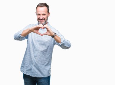 Orta yaş ağarmış üst düzey iş adamı aşık kalp simgesi ve elleriyle şekil gösteren gülümseyen izole arka plan üzerinde. Romantik kavramı.