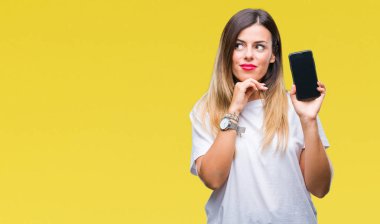 Boş ekran smartphone izole arka plan ciddi bir yüz düşünme hakkında soru, çok karışık bir fikir üzerinde gösterilen genç güzel kadın