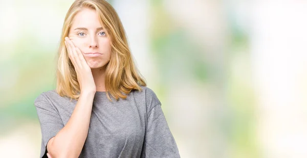 美丽的年轻女子穿着超大的休闲 T恤在孤立的背景认为疲惫和厌倦与交叉手臂抑郁症的问题 — 图库照片