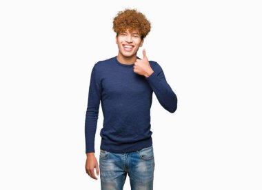 Yakışıklı genç afro saçlı hareketi el ile mutlu Yaşasın yapıyor. Başarı gösteren kameraya bakarak ifade onaylama.