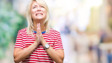Genç güzel sarışın kadın dilencilik ve umut ifade yüzünde çok duygusal ve endişe ile birlikte elleriyle dua izole arka plan yüzünden. Bağışlanmak. Din kavramı.
