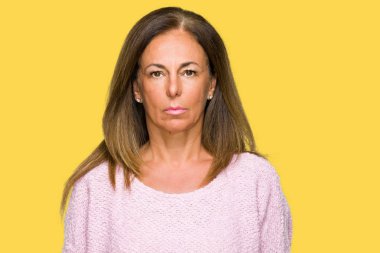 Yüzünde ciddi bir ifade ile izole arka plan üzerinde kış kazak giyen güzel orta yaş yetişkin kadın. Basit ve doğal kameraya bakıyor.