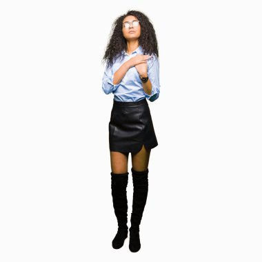 Kıvırcık saçlı gözlüklü kapalı gözler ile göğüs ellerinde ve yüzünde minnettar jest ile gülümseyen genç güzel iş kız. Sağlık kavramı.