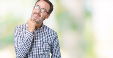 Çene düşünme hakkında soru, dalgın ifade üzerine el ile izole arka plan üzerinde gözlük takan yakışıklı orta yaş zarif üst düzey iş adamı. Düşünceli yüzüyle gülümsüyor. Şüphe kavramı.