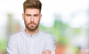 Yakışıklı delikanlı şüpheci ve sinir, onaylamayan ifade yüz çapraz kolları üzerinde. Negatif kişi.