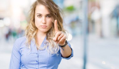 Güzel genç sarışın iş kadını izole üzerinde arka plan işaret parmağını ve kızgın ifade ile