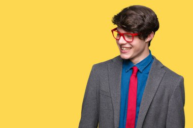 Üzerinde kırmızı gözlük takan genç yakışıklı iş adamı arka plan uzak tarafına gülümseme ile yüzünde, doğal ifade arıyorum izole. Kendine güvenen gülüyor.