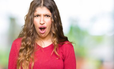 Şüpheci ve alaycı, seyir şok yüzüne kırmızı kazak giyen genç güzel kadın ile açık ağız şaşırttı