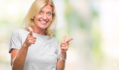 Orta yaş sarışın kadın kamera ile mutlu ve komik yüz için parmakları işaret izole arka plan yüzünden. İyi enerji ve vibes.