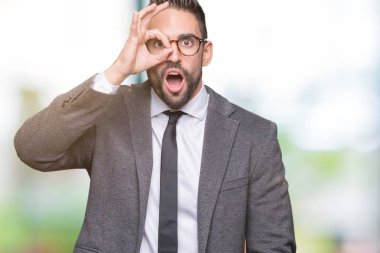 Genç yakışıklı iş adamı ok jest yapıyor izole arka plan üzerinde sürpriz yüz, göz parmaklarının arasından seyir ile şok. İmansız ifade.