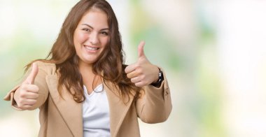 Artı boyutu genç kadın güzel izole arka plan onaylama üzerinde giyen kış ceket el ile pozitif jest yapıyor gülümseyen ve başarı için mutlu yaşasın. Kamera, kazanan jest arıyorsunuz.