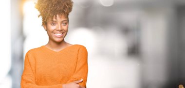 Güzel genç Afro-Amerikan kadın izole arka plan mutlu yüz çapraz silah kameraya bakarak ile gülümseyen yüzünden. Olumlu bir kişi.