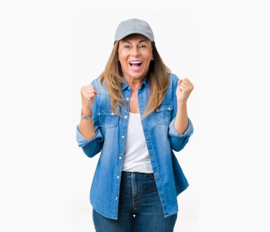 Güzel orta yaş kadın izole arka plan kutlama üzerinde spor şapkası şaşırttı ve başarı için kaldırdı Kollarını açarak hayret ve gözleri açık. Kazanan kavramı.