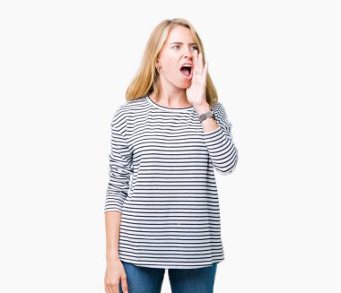 Bağırarak ve ağzı üzerinde el ile yan için çığlık izole arka plan üzerinde çizgili Süveter giyen güzel genç kadın. İletişim kavramı.