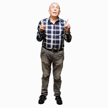 Casual gömlek giymiş yakışıklı komuta sizde hayrete ve yukarıya bakıyor ve parmakları ile işaret ve silah kaldırdı şaşırttı.