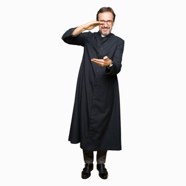 Katolik giyen orta yaş rahip adam robe ile büyük ve büyük boy işaret, ölçü birimi sembol gösteren el el hareketi. Kameraya bakarak gülümsüyordu. Ölçüm kavramı.